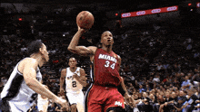 a man in a miami 34 jersey holds a basketball