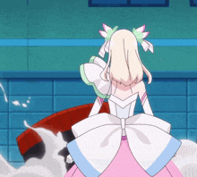 a girl in a pink and white dress with a bow
