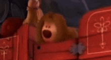 a stuffed animal is sitting in a red wagon .