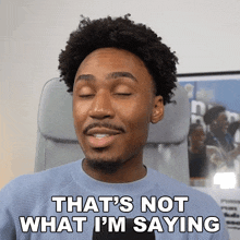 a man sitting in an office chair with his eyes closed and says " that 's not what i 'm saying "