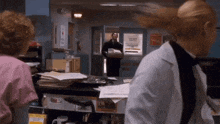 a woman in a lab coat stands in front of a sign that says ' emergency room '