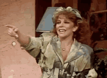 a woman in a dirty jacket is pointing and smiling