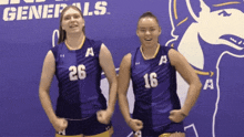 two girls wearing purple uniforms with the number 26 and 16