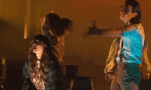 a group of people dancing in a dark room with a man wearing suspenders