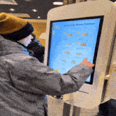 a man is using a mcdonald 's kiosk to order a burger