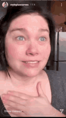 a close up of a woman 's face with her hands on her chest