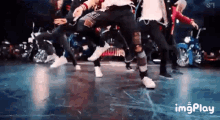 a group of young men are dancing on a stage .