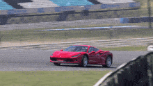a red sports car is driving on a track with a sign that says s on it