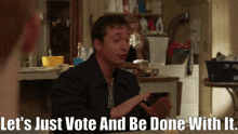 a man sitting at a table with the words let 's just vote and be done with it