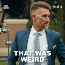 a man in a suit and tie says that was weird in front of a microphone