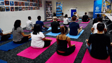 a group of people are sitting on yoga mats in front of a ubisoft sign