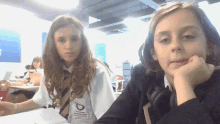two girls are sitting in a classroom and one has a shirt that says ' manchester ' on it