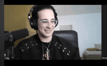 a man wearing headphones and glasses is smiling while sitting in front of a microphone with the name luka at the bottom