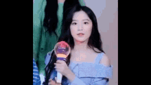 a girl in a blue dress is holding a light stick in her hand .