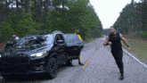 a man is running towards a black jeep with the door open