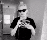 a woman wearing sunglasses and a black t-shirt with the word scream on it