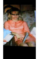 a woman in a pink dress is sitting on a couch