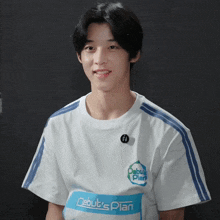 a boy wearing a white shirt with the words debut 's plan on it