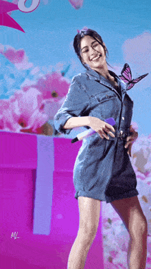 a woman in a denim dress is dancing with a butterfly