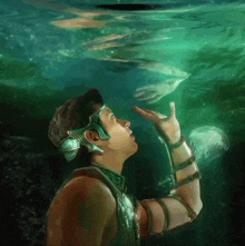 a man is looking up at a jellyfish in the ocean