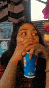 a woman drinking from a pepsi can in front of a tom jerry sign