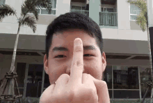 a man is giving the middle finger to the camera