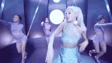 ariana grande is dancing in a video with a group of dancers .