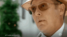 a close up of a man wearing sunglasses and a hat with the hashtag #theblacklist on the bottom