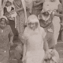 a black and white photo of a man carrying another man on his back