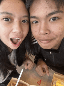a man and a woman are posing for a picture in front of a mcdonald 's box of food
