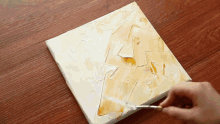 a person is painting a picture on a canvas with a knife