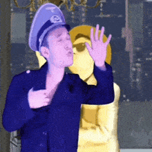 a man wearing a purple hat and a blue jacket is standing next to a yellow figure