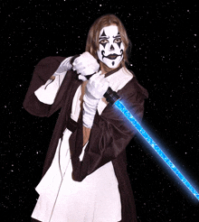 a woman in a clown costume holds a blue light saber