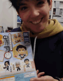 a person holding a book that says ' demon slayer ' on the cover