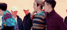 a group of young men are standing next to each other and talking .