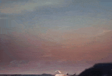 a sunset over a body of water with a boat in the distance .