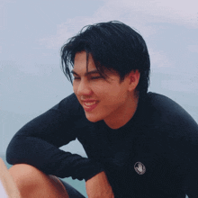 a young man wearing a black long sleeve shirt with a hand on it