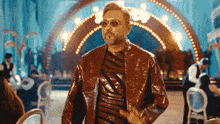 a man in a red jacket and sunglasses is standing in a room