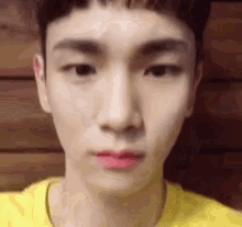 a close up of a man 's face with a yellow shirt on .