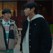 two young men standing next to each other in front of a building that says ' abercrombie & fitch '