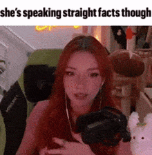 a woman with red hair is wearing headphones and holding a camera .