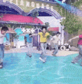 a group of people are dancing in a pool in front of a building that says language .