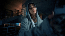 a person in a hoodie taking a selfie with a phone