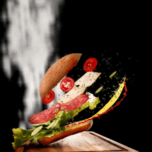 a sandwich with lettuce tomatoes and mustard is being thrown into the air