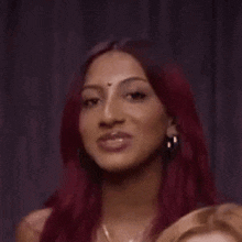 a woman with red hair and earrings is smiling and looking up .