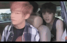 a group of young men are sitting in the back of a car .
