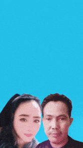 a man and a woman are standing next to each other with a blue background
