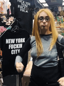 a woman wearing glasses stands in front of a new york fuckin city shirt