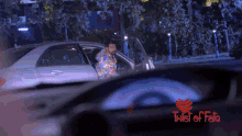 a man is getting out of a car with a twist of fate logo in the background