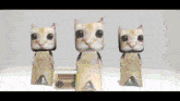 three cardboard cats are standing next to each other and a radio